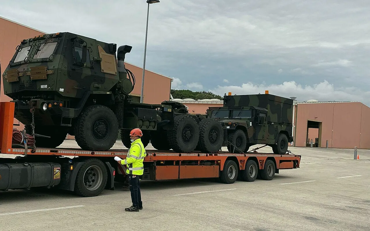 US Army vehicles loaded on a commercial lowboy trailer for transport