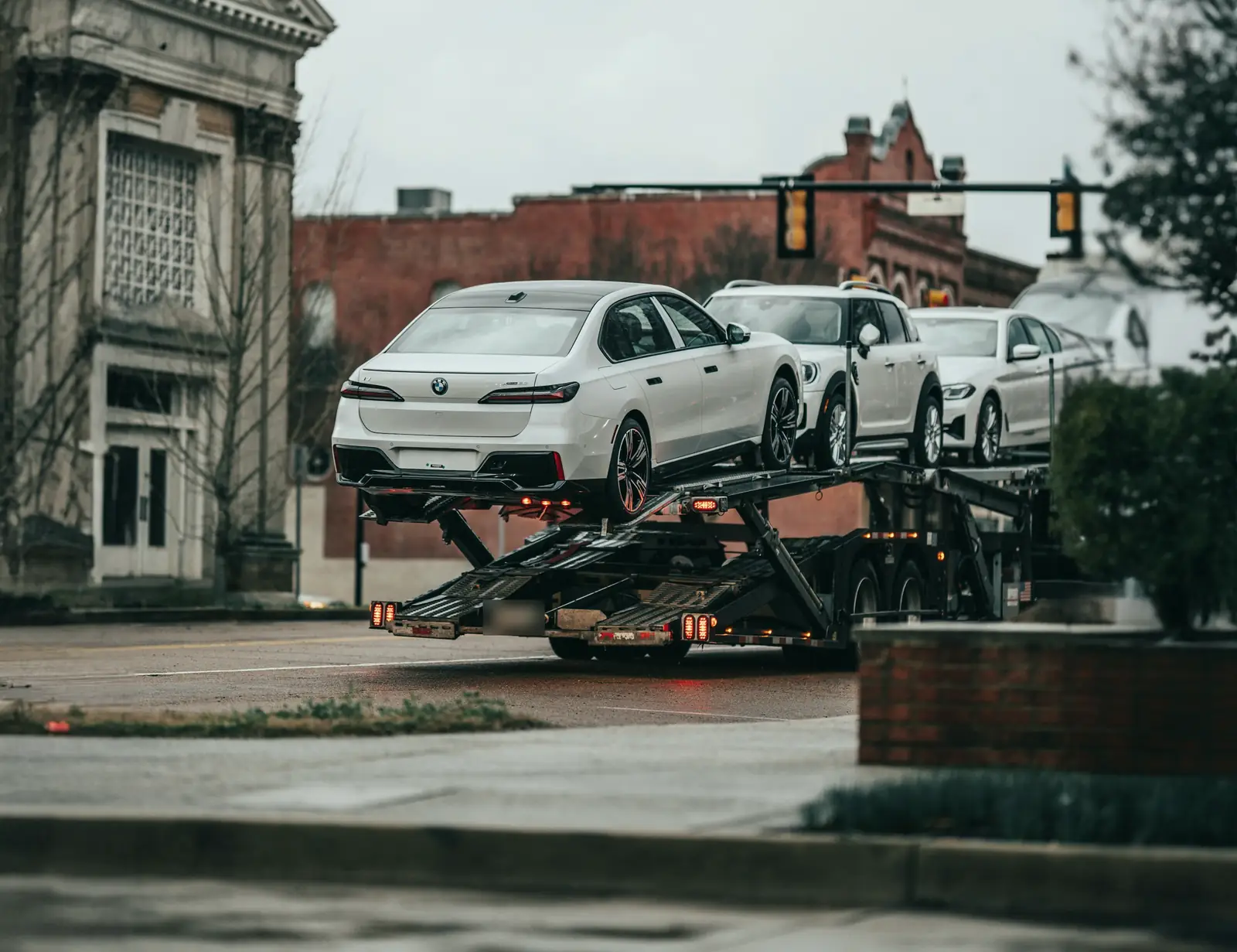 A car carrier loaded with new vehicles on a town main street
